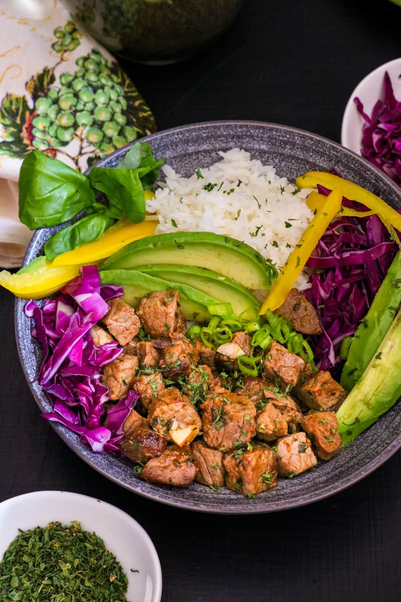 steak bites, rice, veggies on gray plate