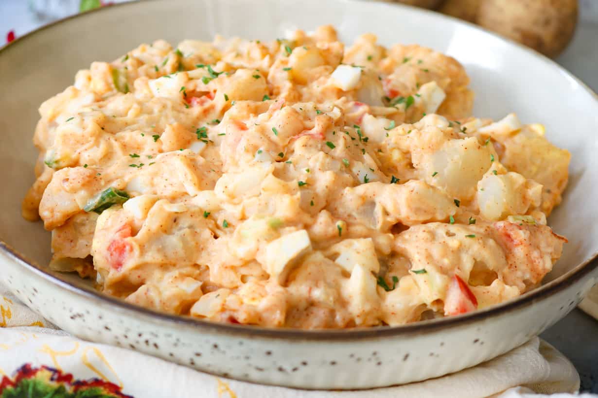 creamy potato salad in brown spotted bowl