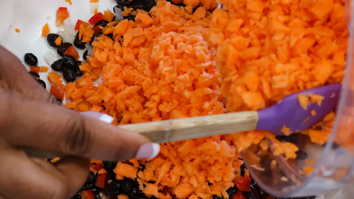 adding diced sweet potatoes to beans and bell pepper