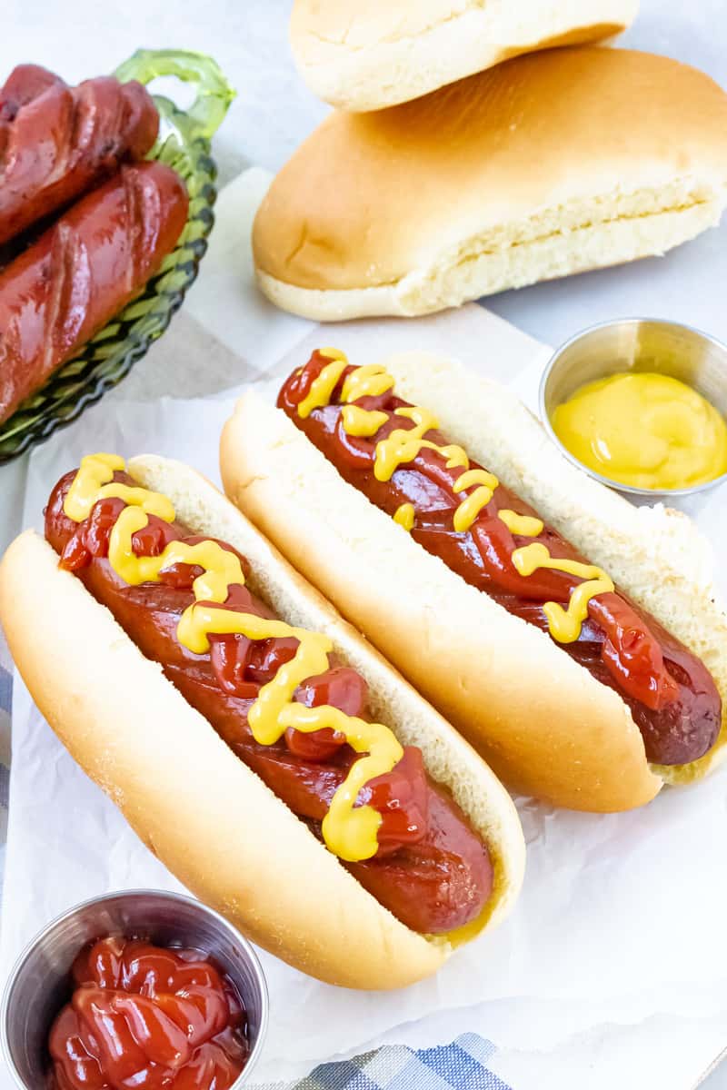 vertical view of beef franks top with ketchup and mustard