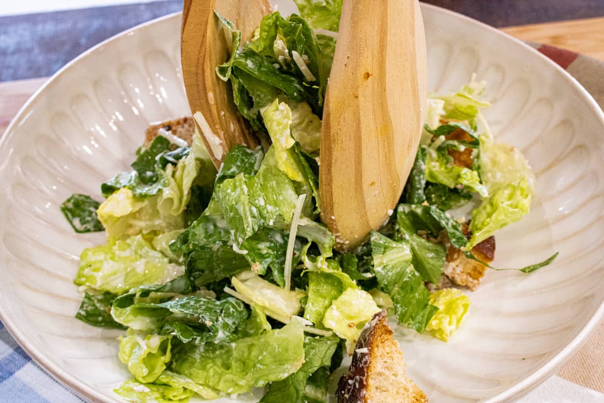 placing Caesar salad in bowl