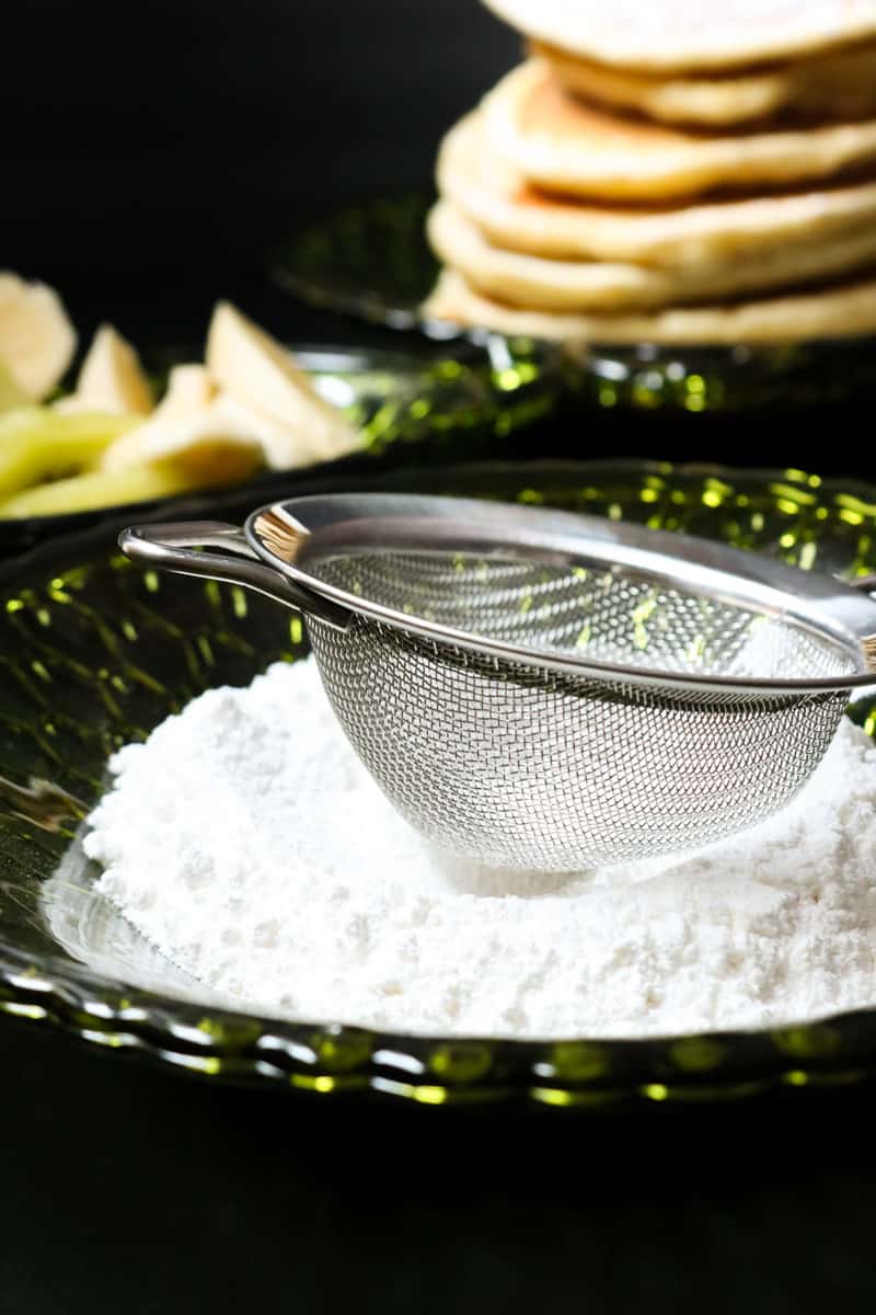 sugar on green plate with sieve