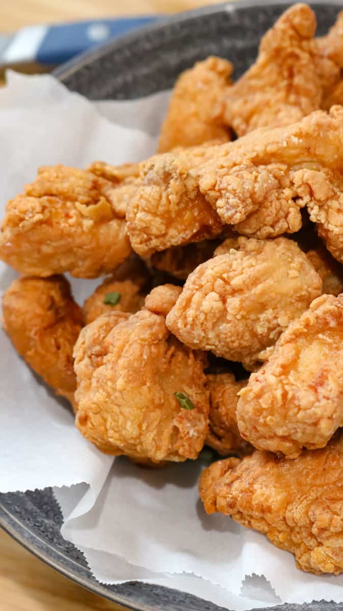 fried chicken in bowl lined with parchment paper