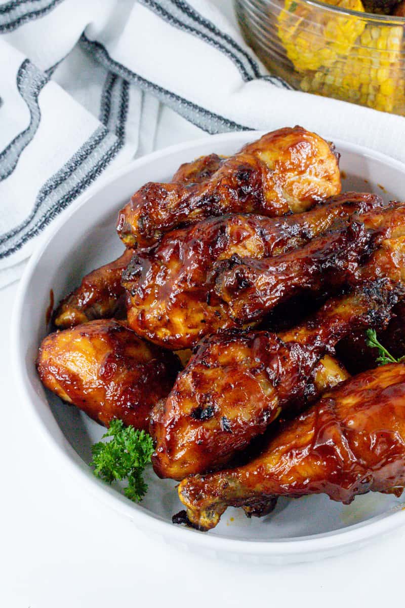 cooked bbq legs in white bowl with parsley