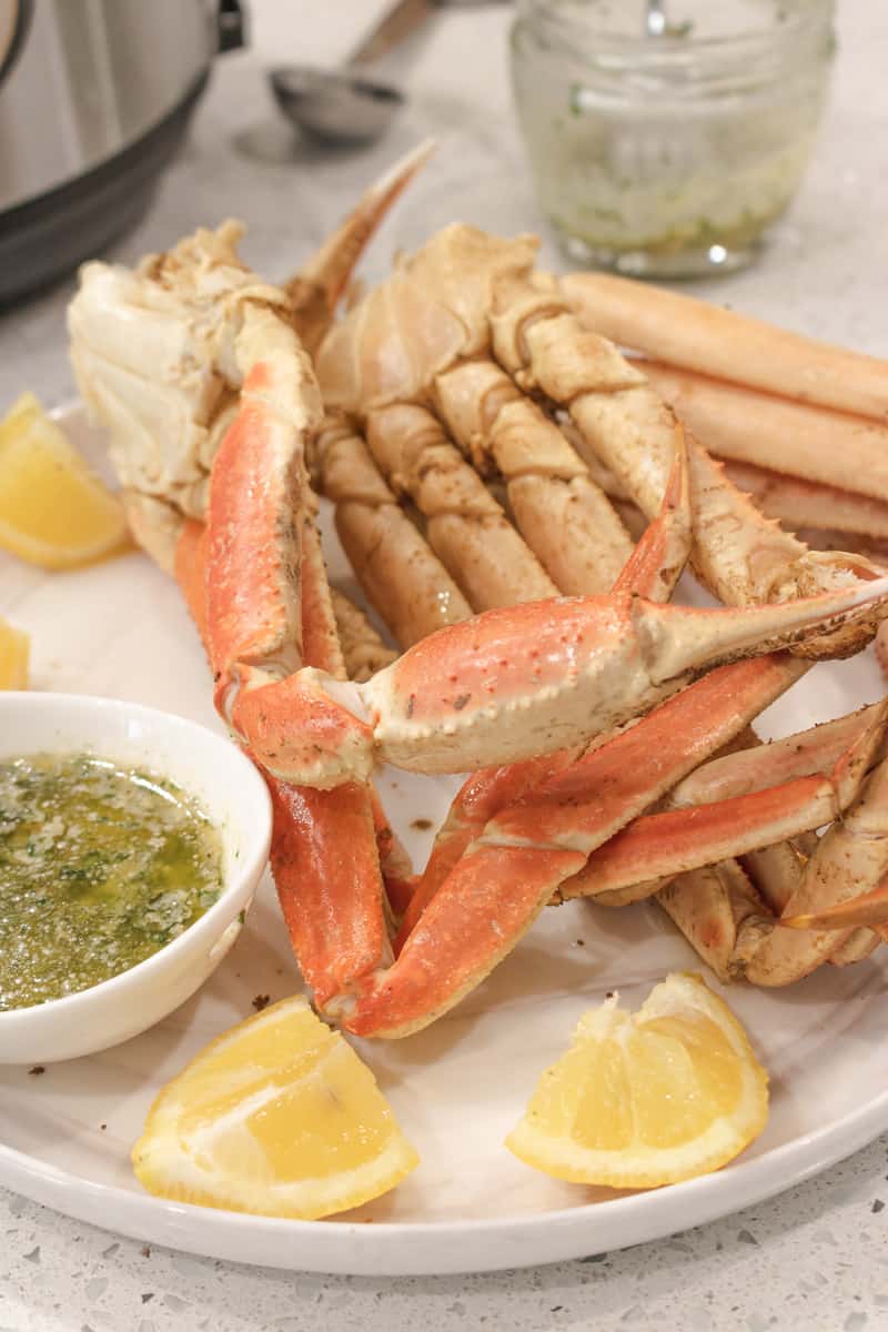 instant pot crab legs on white plate with lemon wedges