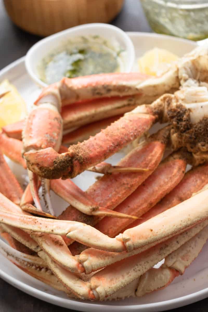 instant pot crab legs on white plate with lemon wedges