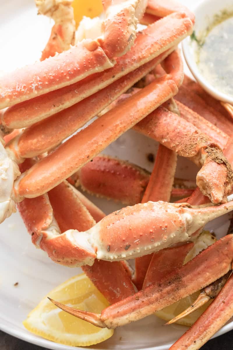 instant pot crab legs on white plate with lemon wedges