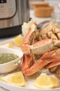instant pot crab legs on white plate with lemon wedges