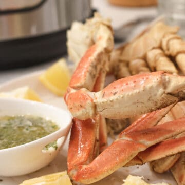 instant pot crab legs on white plate with lemon wedges