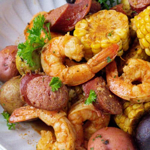low country shrimp boil in white plate with parsley