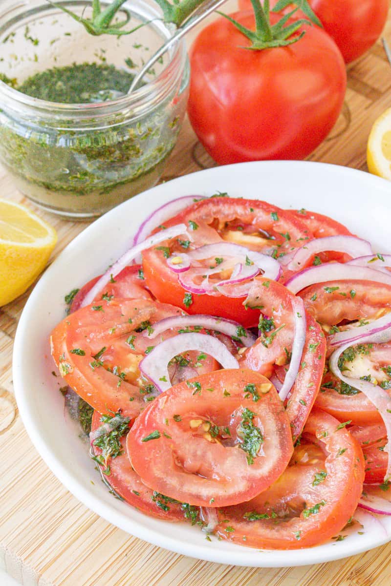 tomatoes, onions, and herbs in white plate