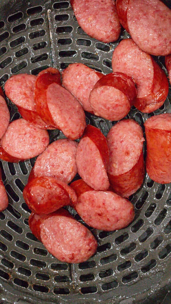 uncooked sausage in air fryer basket