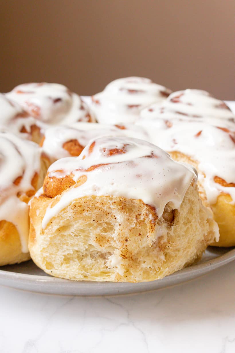 cinnamon rolls topped with cream cheese frosting on gray plate