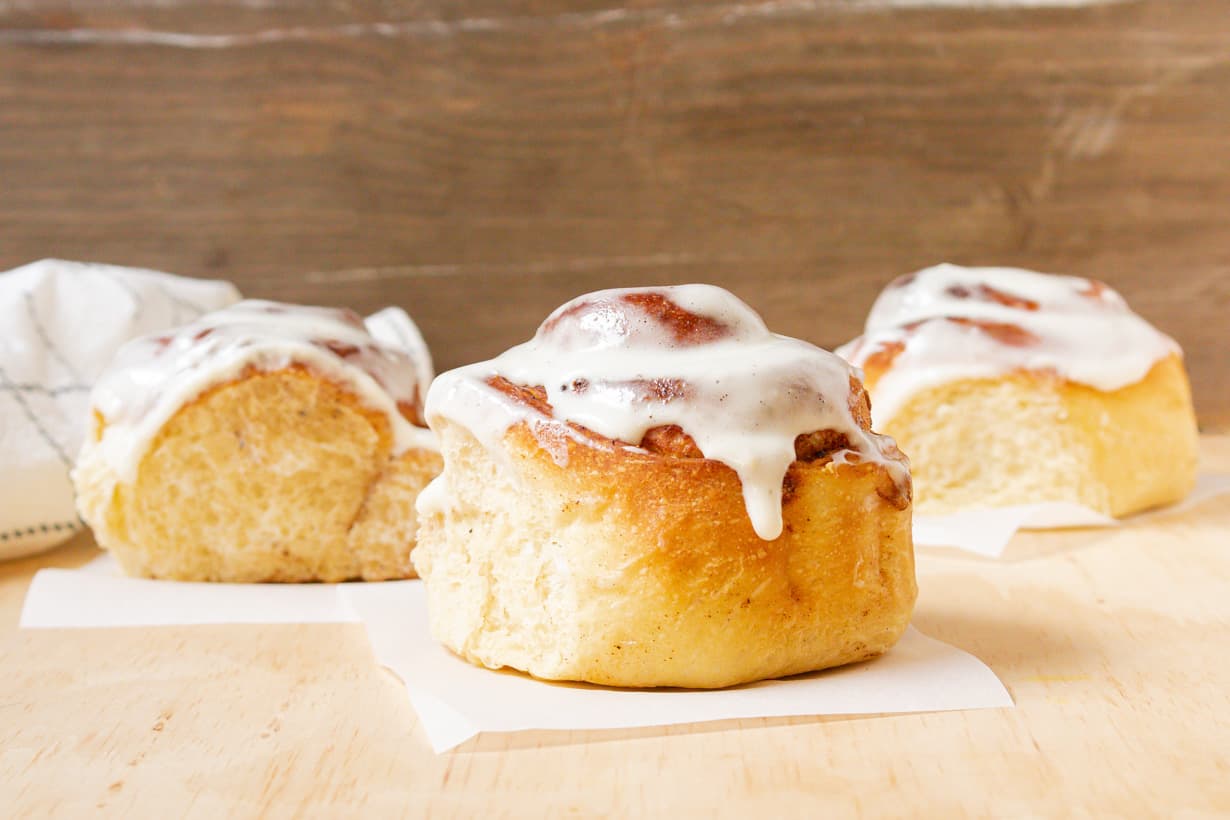 air fryer cinnamon rolls on parchment paper and wooden table