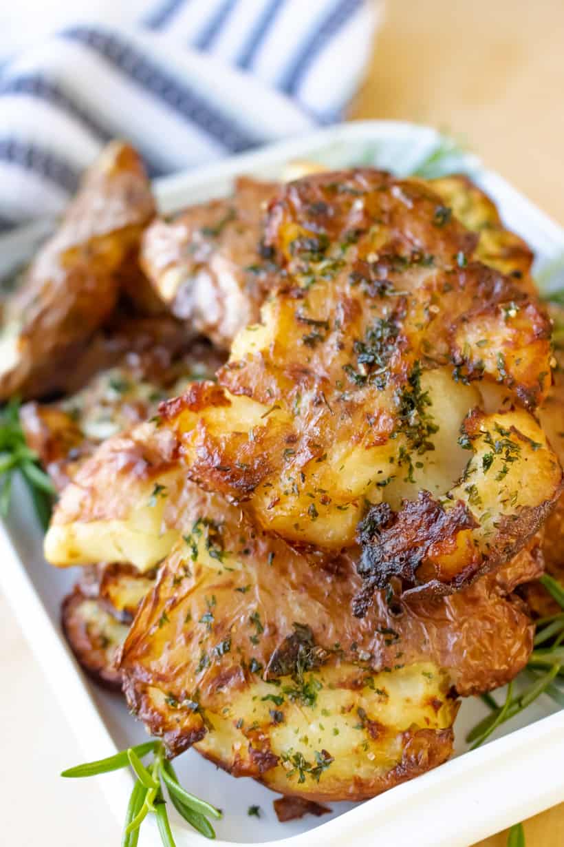 potatoes on board with rosemary in white tray