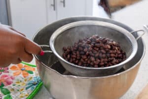 cooked black beans straining in sieve.