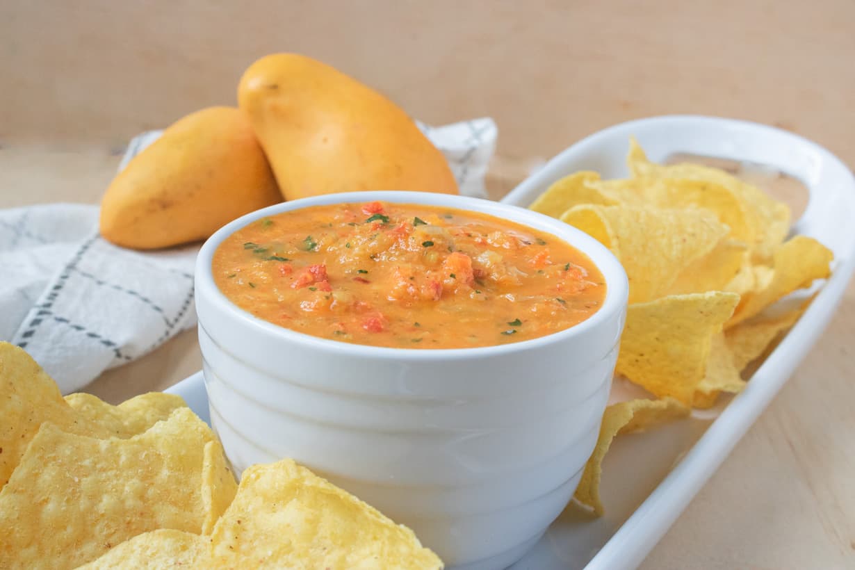 close up view Mango salsa in white bowl with chips