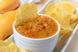 Mango salsa in white bowl with chips