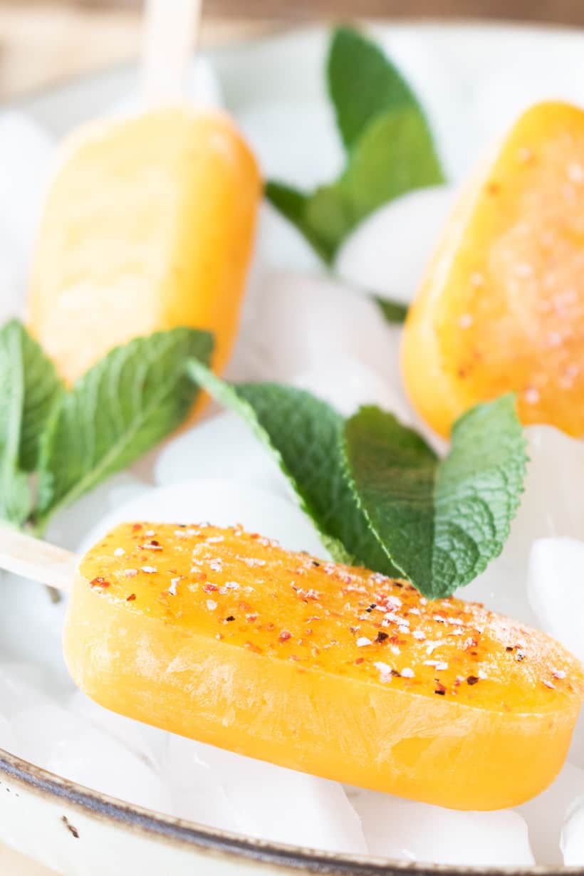 mango popsicle with Tajin on ice and mint