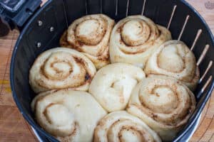 rolled air fryer cinnamon rolls in air fryer basket.