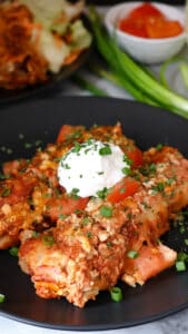 Sour Cream Chicken Enchiladas on black plate