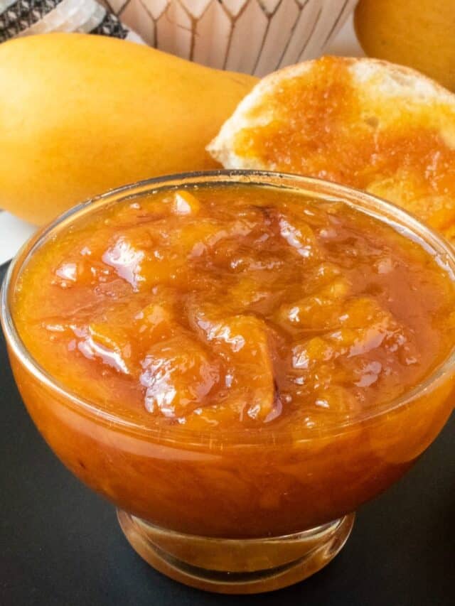 mango jam in glass jar on black plate