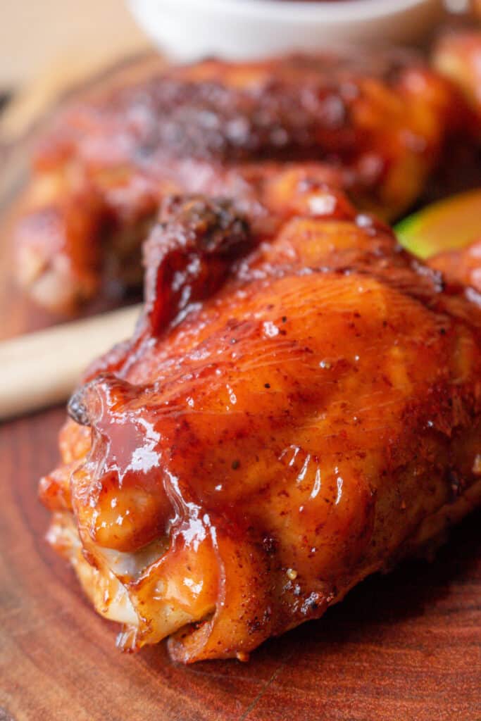 smoked bbq chicken thigh on wooden board