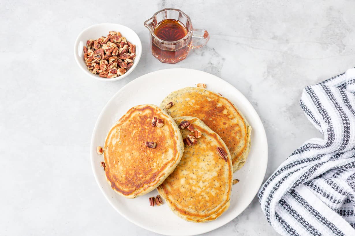 pancakes, syrup, and nuts on gray board