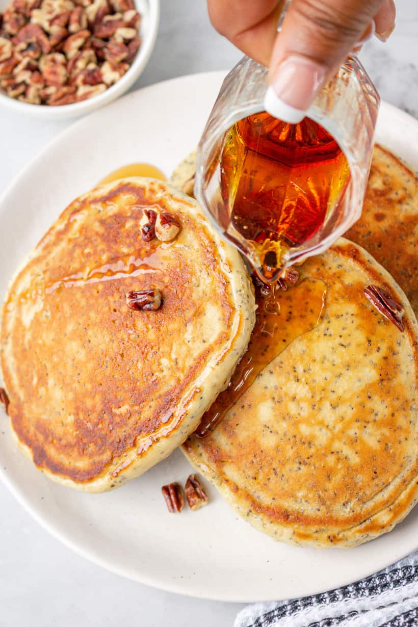 pouring syrup over pancakes