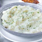 Mashed Potatoes in gray bowl on top of white plate
