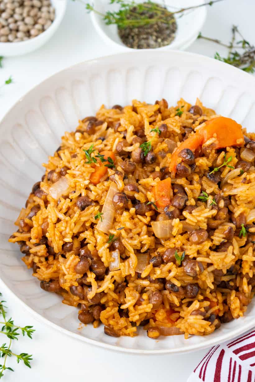 rice and pigeon peas in white bowl with herbs