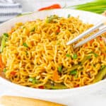 lo mein noodles in white bowl with silver chopsticks.