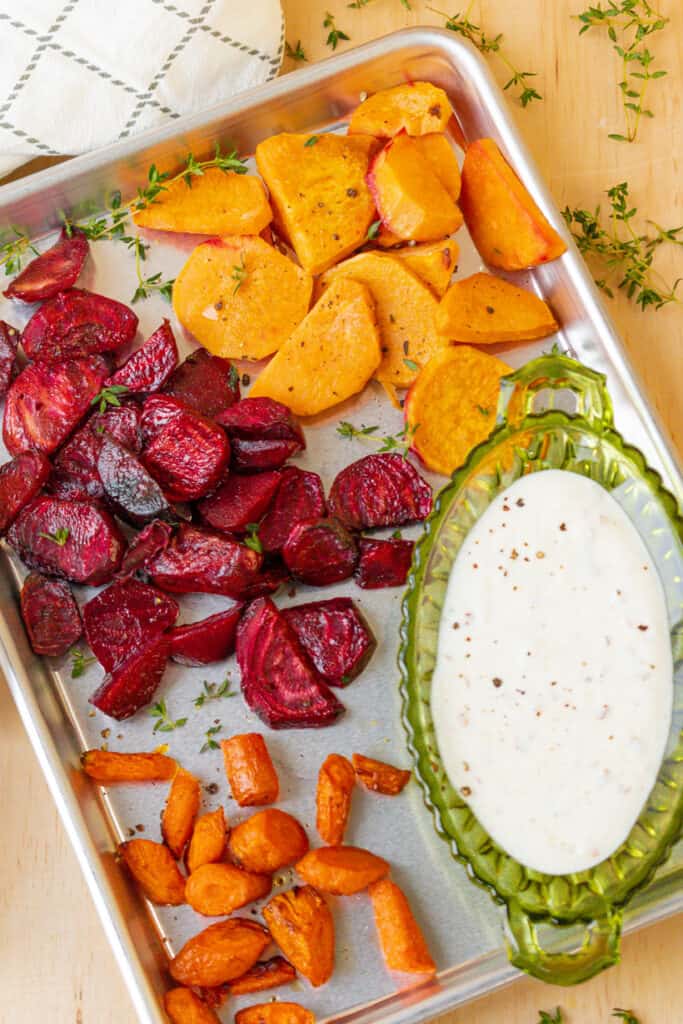 air fryer roasted vegetables in baking tray with yogurt sauce