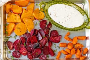 air fryer roasted vegetables in baking tray with yogurt sauce