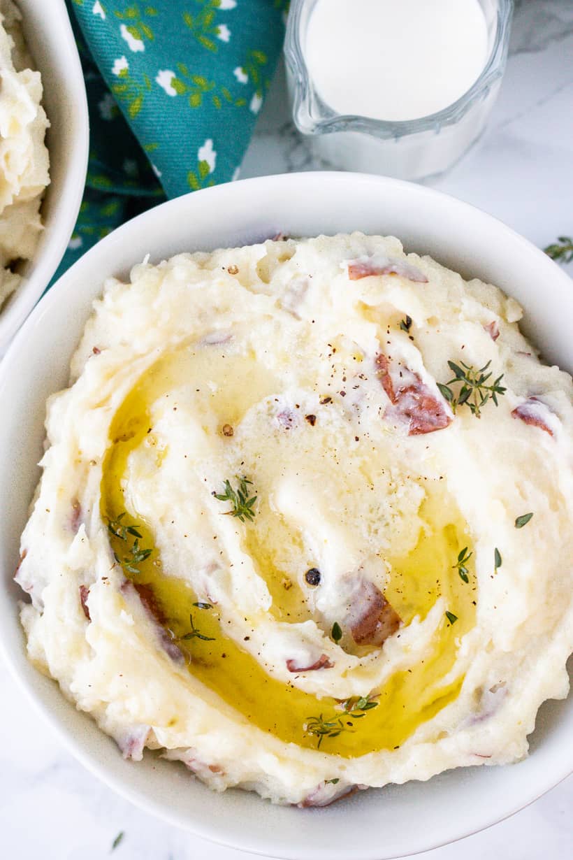 instant pot red mashed potatoes in white bowl with creamer on the side