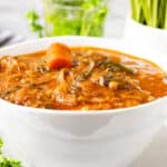 Okra Stew Recipe in white bowl with fresh parsley in the background