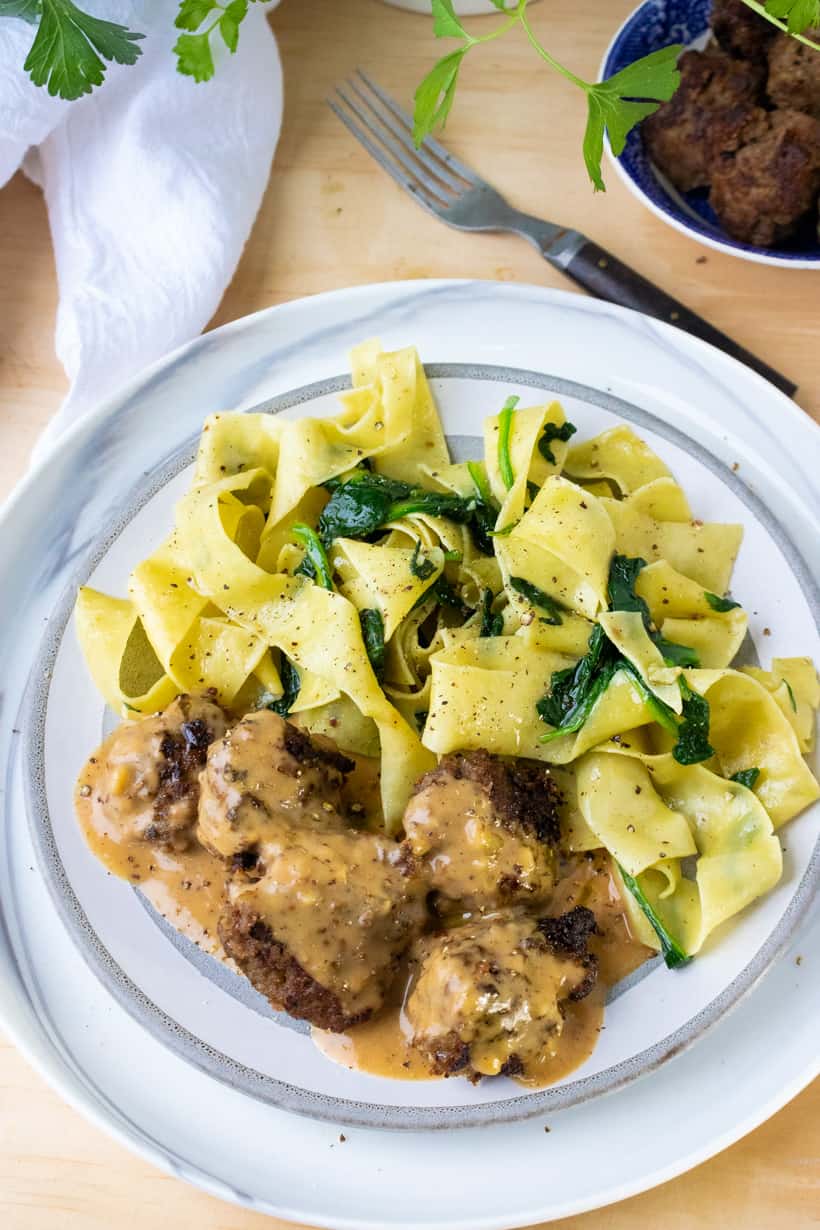 Swedish meatballs with noodles on white plate