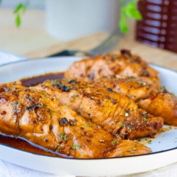 4 salmon fillets in a white plate