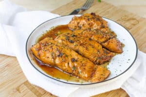 salmon fillets on white plate on wooden cutting board