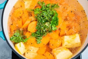 herbs on top of pumpkin, carrots, and potatoes