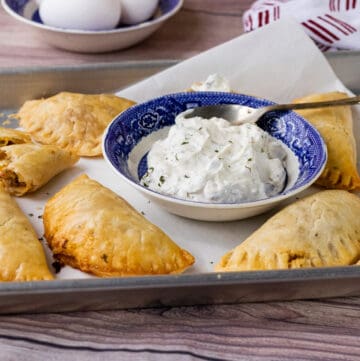 empanadas in tray with sauce