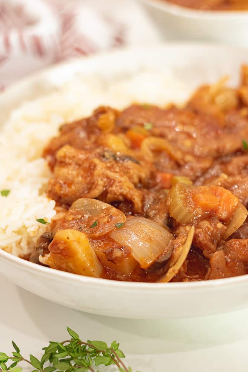 veal stew in white plate with rice