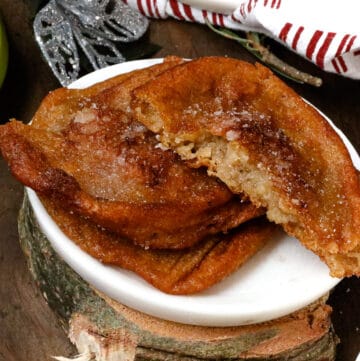 cut out beignets on white plate over wood