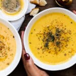 Hand holding bowl with cooked Turkish style red lentil soup