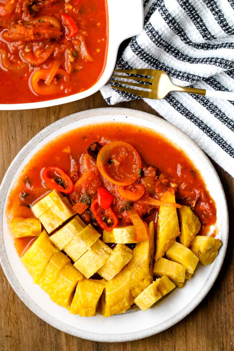 plantains, sauce aransel and fork on wooden background