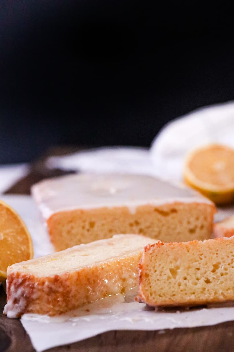 lemon loaf cake with lemon slices on parchment paper
