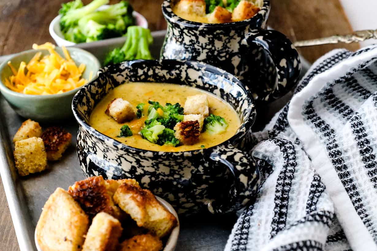 soup topped with broccoli and bread