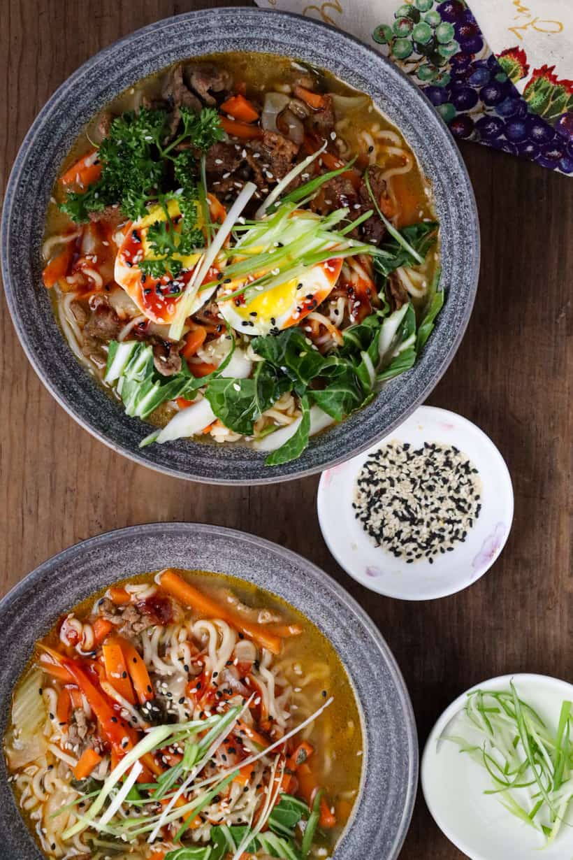 ramen noodle soup with beef and eggs in gray bowl