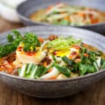 beef ramen soup topped with herbs in gray bowl