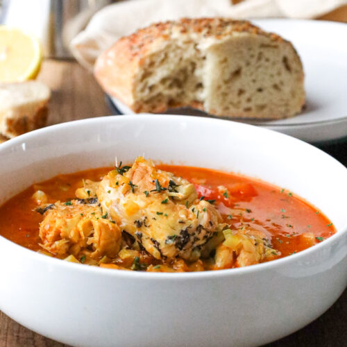 bouillabaisse fish stew in white bowl with bread
